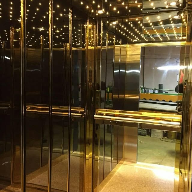کابین آسانسور آینهای طلایی با نورپردازی سقف